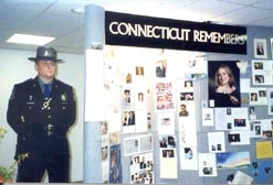 Photo of an Officier next to Memorial Board